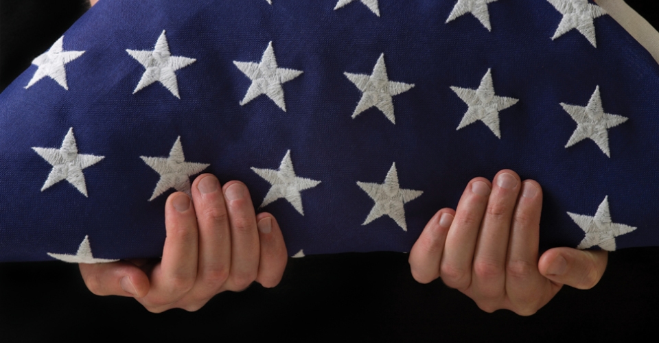 Image of person holding folded flag