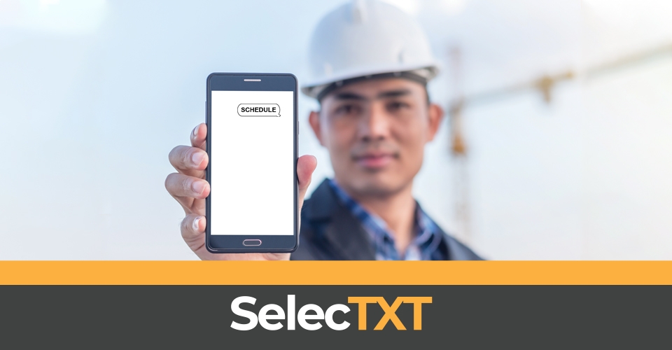 Construction worker holding up cell phone